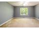Bright bedroom with a large window and neutral carpet at 215 Odyssey Turn, Conyers, GA 30012