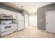 Kitchen view showcasing appliances, white cabinets, and access to other rooms at 215 Odyssey Turn, Conyers, GA 30012