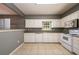 Bright kitchen featuring white cabinets, tile flooring, and modern appliances for a fresh look at 215 Odyssey Turn, Conyers, GA 30012