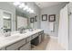 Bathroom featuring dual sinks, large mirror, vanity, and bright lighting over neutral flooring at 2865 Lenox Road Ne # 602, Atlanta, GA 30324