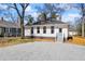 View of back of the home featuring a gravel driveway, freshly painted siding and small stoop at 34 N Broad N St, Porterdale, GA 30014