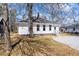 Backyard view of a bright home, with a gravel parking area, well manicured yard and privacy fence at 34 N Broad N St, Porterdale, GA 30014