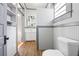 Bathroom boasts gray and white walls, wood-style tiled floor, and built-in storage shelves at 34 N Broad N St, Porterdale, GA 30014