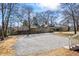 Wide gravel driveway providing ample parking space, set in a verdant neighborhood at 34 N Broad N St, Porterdale, GA 30014