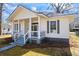 Charming exterior view of a white home with a welcoming front porch and well-maintained landscaping at 34 N Broad N St, Porterdale, GA 30014