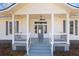 Inviting front porch featuring white columns, a gray floor, and a ceiling fan for outdoor comfort at 34 N Broad N St, Porterdale, GA 30014