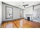 Cozy living room features hardwood floors, neutral paint, fireplace, two windows, and ample natural light at 34 N Broad N St, Porterdale, GA 30014