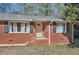 Close up of the home's entryway, featuring a brick facade, black shutters, and a small porch at 1276 Clay Sw Rd, Mableton, GA 30126