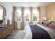 Bright bedroom featuring wood floors, large windows with curtains, wood accent wall, and dresser at 1578 Driggs Nw Dr # 171, Atlanta, GA 30318