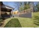 Home's beautiful backyard has a retaining wall and newly installed fencing, and well-manicured lawn at 262 Green Hill Ne Rd, Sandy Springs, GA 30342