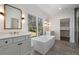 Modern bathroom featuring dual vanities, soaking tub under a large window, and glass-enclosed shower at 262 Green Hill Ne Rd, Sandy Springs, GA 30342