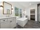 Modern bathroom with a freestanding tub, double vanity, and a large window for natural light and gray tiled floor at 262 Green Hill Ne Rd, Sandy Springs, GA 30342