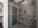 Modern shower with dark gray tile, glass enclosure, and sleek fixtures, creating a luxurious bathing experience at 262 Green Hill Ne Rd, Sandy Springs, GA 30342