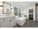 Modern bathroom with dual vanities, soaking tub under a large window, and glass-enclosed shower at 262 Green Hill Ne Rd, Sandy Springs, GA 30342