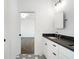 Bathroom with double vanity, dark countertops, and geometric tile flooring that connects to the bedroom at 262 Green Hill Ne Rd, Sandy Springs, GA 30342