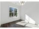 Bedroom with hardwood flooring, a modern light fixture, a large window, and bright white walls at 262 Green Hill Ne Rd, Sandy Springs, GA 30342