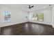 A bright bedroom featuring hardwood floors, ceiling fan, and large windows allowing natural light to flood the space at 262 Green Hill Ne Rd, Sandy Springs, GA 30342