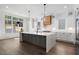 Stylish kitchen with an island, white cabinetry, modern lighting, and a view to the outdoors at 262 Green Hill Ne Rd, Sandy Springs, GA 30342