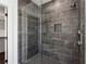 Modern shower with gray tile walls, a rainfall shower head, and a built-in niche for toiletries at 262 Green Hill Ne Rd, Sandy Springs, GA 30342