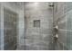 Modern shower with gray tile walls, a rainfall shower head, and a built-in niche for toiletries at 262 Green Hill Ne Rd, Sandy Springs, GA 30342