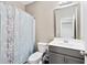 Bathroom with gray vanity, neutral walls, and patterned shower curtain for an updated look at 1262 Park Pass Row, Suwanee, GA 30024