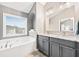 Bathroom featuring double sinks with granite countertops and a large soaking tub at 1262 Park Pass Row, Suwanee, GA 30024