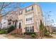 Charming two-story townhouse featuring light beige siding, dark shutters, a brick foundation and inviting front garden at 1262 Park Pass Row, Suwanee, GA 30024
