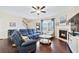 Inviting living area with a fireplace, plush seating, hardwood floors, and natural light streaming through the windows at 1262 Park Pass Row, Suwanee, GA 30024