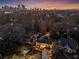 Aerial view of a suburban home with a city skyline backdrop and tree lined street at 1352 Middlesex Ne Ave, Atlanta, GA 30306