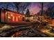 Beautiful backyard with a red cabana, stream and the back of the main house, illuminated with landscape lighting at 1352 Middlesex Ne Ave, Atlanta, GA 30306