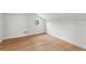 Lofted bedroom with hardwood floors, unique window, white walls, and closet storage with wire shelving at 1352 Middlesex Ne Ave, Atlanta, GA 30306