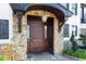 Grand entrance featuring a stone facade, a covered porch, and an elegant solid wood front door at 1352 Middlesex Ne Ave, Atlanta, GA 30306