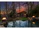 Backyard pool with cabana, spa, fire features, and lush landscaping illuminated at dusk at 1352 Middlesex Ne Ave, Atlanta, GA 30306