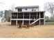 Enjoy the spacious backyard featuring a screened porch, stairs, and a charming seating area with wooden chairs at 4040 Merritt Dr, Cumming, GA 30041