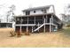 Expansive backyard featuring a screened porch, stairs, and a charming seating area with wooden chairs at 4040 Merritt Dr, Cumming, GA 30041