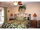 Comfortable bedroom boasts a tropical themed comforter, ceiling fan, and two nightstands with lamps at 4040 Merritt Dr, Cumming, GA 30041