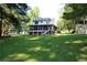Exterior of home featuring a screened porch, well-maintained lawn, and mature trees at 4040 Merritt Dr, Cumming, GA 30041