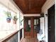 Covered front porch with wood ceiling, railing, seating, and hanging potted plants at 4040 Merritt Dr, Cumming, GA 30041