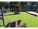 Expansive front yard with lush green grass, mature trees, and a well-maintained lawn at 4040 Merritt Dr, Cumming, GA 30041