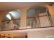 View of the home's loft, showing the arched entries with wood railing overlooking the main living space at 4040 Merritt Dr, Cumming, GA 30041