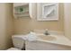 Bathroom includes a toilet and single sink with a large mirror and a shelf for storage at 1283 Hada Ct, Lawrenceville, GA 30043