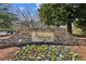 Stone sign displaying the community name amidst vibrant flowers, creating an inviting and picturesque entrance at 1283 Hada Ct, Lawrenceville, GA 30043