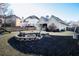 Backyard with a brick fire pit, seating, green grass, and bordered by black mulch at 2250 Snug Ne Hbr, Marietta, GA 30066