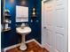 Charming bathroom with a pedestal sink, a white cabinet, and blue walls creating a vintage aesthetic at 2250 Snug Ne Hbr, Marietta, GA 30066