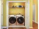 Laundry room with full size washer and dryer, overhead shelf, and white bi-fold doors at 2250 Snug Ne Hbr, Marietta, GA 30066