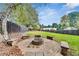 Wide shot of a fenced backyard featuring a stone fire pit area and mature trees at 3580 S Sherwood Se Rd, Smyrna, GA 30082