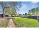 Large, fenced backyard features a brick walkway, grassy area, and stone fire pit area at 3580 S Sherwood Se Rd, Smyrna, GA 30082