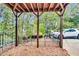 Outdoor living space with a wood-covered patio, fenced yard, basketball court, and mature trees at 3580 S Sherwood Se Rd, Smyrna, GA 30082