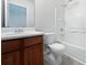 A cozy bathroom featuring a wooden vanity, white walls, shower with tub, and neutral floor at 11403 S Grove Dr, Hampton, GA 30228