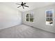 Minimalist bedroom with large windows, plush carpet, and ceiling fan at 11403 S Grove Dr, Hampton, GA 30228